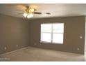 View of the empty bedroom featuring tan carpeting and a large window at 1044 S Mosley Dr, Chandler, AZ 85286