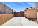 Long driveway leading to a gated backyard, with a tan stucco wall at 10520 W Patrick Ln, Peoria, AZ 85383