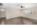 Bright room featuring wood-look floors, ceiling fan with light, and neutral color palette at 1215 W Dublin St, Chandler, AZ 85224