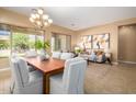 Open concept dining area with wood table, white chairs, and bright natural light at 12820 W La Vina Dr, Sun City West, AZ 85375