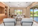 Bright living room featuring neutral walls, built-in shelving, and large windows overlooking the backyard at 12820 W La Vina Dr, Sun City West, AZ 85375