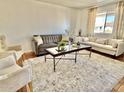 Bright and airy living room with comfortable seating, a patterned rug, and large window at 1337 W Elna Rae St, Tempe, AZ 85281