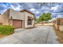 View of a driveway and garage with stone accents, complemented by a well-maintained landscape at 150 N Lakeview Blvd # 1, Chandler, AZ 85225