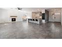 An open-concept living space with gray tile floors, a fireplace, and a kitchen island with bar seating at 16617 S 16Th Ave, Phoenix, AZ 85045