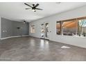 Open-concept living room featuring gray tile flooring, large windows, and view of pool at 16617 S 16Th Ave, Phoenix, AZ 85045