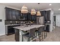 Modern kitchen with a granite countertop island, stainless steel appliances and designer lighting at 21512 S 225Th Way, Queen Creek, AZ 85142