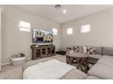 Cozy living room with plush seating, neutral tones, and a display of the home's exterior at 285 E Raleigh Dr, Chandler, AZ 85286