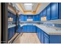 Stylish kitchen with custom blue cabinetry, stainless steel appliances, and a light-filled skylight at 3022 E Weldon Ave, Phoenix, AZ 85016