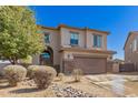 Two-story home with a two-car garage, desert rock landscape, and neutral stucco facade at 599 W Agrarian Hills Dr, San Tan Valley, AZ 85143