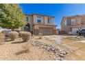 Two-story home boasts a two-car garage, neutral stucco, low maintenance landscaping, and a desert rock feature at 599 W Agrarian Hills Dr, San Tan Valley, AZ 85143