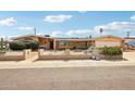 Charming single-story home with desert landscaping, white brick fence, and well-manicured bushes at 6217 W Orange Dr, Glendale, AZ 85301