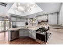 Well lit kitchen features stainless steel appliances, gray cabinets, and a window with a view to the backyard at 730 E Rosemonte Dr, Phoenix, AZ 85024