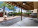 Covered patio showcases a ceiling fan, and a view to the backyard with mature trees at 730 E Rosemonte Dr, Phoenix, AZ 85024