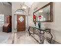 Elegant foyer with marble floors, console table, decorative mirror, and a custom front door at 8531 E San Lorenzo Dr, Scottsdale, AZ 85258