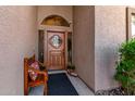 Close-up of a custom wood front door with a decorative glass insert, bench and stone accents at 8531 E San Lorenzo Dr, Scottsdale, AZ 85258