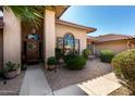 Inviting home entrance with a custom wood door, desert landscaping, and an arched window at 8531 E San Lorenzo Dr, Scottsdale, AZ 85258