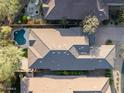 Aerial view of property including tile roof, pool, lush landscaping, backyard patio, and neighborhood at 9435 E Mohawk Ln, Scottsdale, AZ 85255