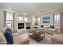 Bright and airy living room featuring a fireplace, plush seating, and abundant natural light from shuttered windows at 9435 E Mohawk Ln, Scottsdale, AZ 85255