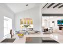 Elegant dining area with modern chandelier and view of the living room beyond at 9675 E Cinnabar Ave, Scottsdale, AZ 85258