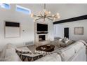 Modern living room featuring a stylish fireplace, designer lighting, and contemporary furnishings at 9675 E Cinnabar Ave, Scottsdale, AZ 85258