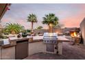 Outdoor kitchen with stainless steel grill and bar area for an exceptional outdoor experience at 1197 W Rolls Rd, San Tan Valley, AZ 85143