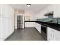 Bright kitchen features white cabinets, stainless steel appliances, and black granite countertops with a blue backsplash at 1209 N 87Th St, Scottsdale, AZ 85257