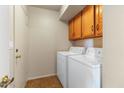 Practical laundry room with washer, dryer, storage cabinets, and a white door at 1209 N 87Th St, Scottsdale, AZ 85257
