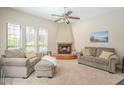 Cozy living room with a fireplace, comfortable seating, and natural light from large windows at 12438 N Saguaro Blvd # 108, Fountain Hills, AZ 85268