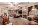 Comfortable living room features a stone fireplace, built-in shelving, and plush furniture at 13331 W Romain Ct, Litchfield Park, AZ 85340
