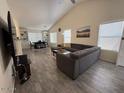 Bright living room features vaulted ceiling, modern gray sofa, and wood-style tile flooring at 1502 E Detroit St, Chandler, AZ 85225