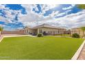 Expansive backyard with an artificial lawn, outdoor dining, and desert landscaping at 17017 N Palo Azul Rd, Maricopa, AZ 85138