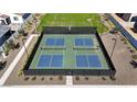 Aerial view of outdoor pickleball courts with professional surfacing, fencing, and lighting for evening play at 17260 W Daley Ln, Surprise, AZ 85387