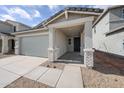 Charming home featuring a concrete driveway, brick accents, and covered front entry at 17266 W Daley Ln, Surprise, AZ 85387