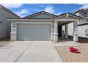 Charming home featuring a concrete driveway, brick accents, and a covered entryway at 17266 W Daley Ln, Surprise, AZ 85387