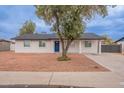 Charming single-story home featuring a blue front door, white exterior, and low-maintenance landscaping at 1816 W Villa Maria Dr, Phoenix, AZ 85023