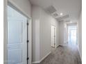 Bright hallway featuring modern tile flooring and white paneled doors at 18243 W Daley Ln, Surprise, AZ 85387