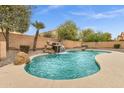 Backyard pool with rock waterfall feature, complemented by mature landscaping and a serene atmosphere at 2280 E Aloe Pl, Chandler, AZ 85286