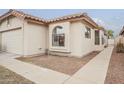 Exterior side view of a beige single-story home with desert landscaping and a tiled roof at 4545 N 67Th Ave # 1106, Phoenix, AZ 85033