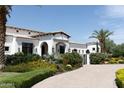 Stunning white stucco home with lush landscaping and a circular driveway at 5802 E Donna Ln, Paradise Valley, AZ 85253