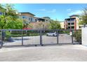 Electronic security gate, lush landscaping and exterior view of the building at 6166 N Scottsdale Rd # C4004, Paradise Valley, AZ 85253