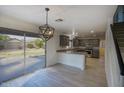 Eat-in kitchen featuring modern light fixtures, stainless steel appliances, and sliding glass door to patio at 6608 W Whispering Wind Dr, Glendale, AZ 85310