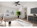 Bright bedroom with a ceiling fan, large window, and ensuite bathroom at 7056 W Caron Dr, Peoria, AZ 85345
