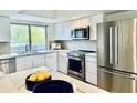 Modern kitchen boasts stainless steel appliances, white cabinetry, and a bright window view at 7232 N Via Camello Del Norte -- # 3, Scottsdale, AZ 85258