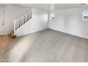 Spacious living room features neutral carpeting and staircase access to the second floor at 7720 W Pipestone Pl, Phoenix, AZ 85035