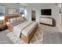 Comfortable main bedroom showcasing a wooden bed frame, soft colors, and modern accents at 7720 W Pipestone Pl, Phoenix, AZ 85035
