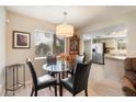 Bright dining area with modern chandelier and views to the kitchen and backyard at 9736 N 95Th St # 126, Scottsdale, AZ 85258