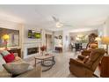 Inviting living room featuring a fireplace, ceiling fan, and sliding glass door to the exterior at 9736 N 95Th St # 126, Scottsdale, AZ 85258