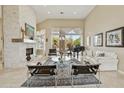 Bright living room featuring a fireplace, piano, large windows, and modern furnishings at 11216 E Appaloosa Pl, Scottsdale, AZ 85259