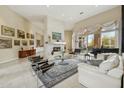 Open concept living room with high ceilings, tile floors, and a white stone fireplace at 11216 E Appaloosa Pl, Scottsdale, AZ 85259