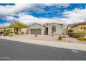 Single-story home with well-manicured landscaping and desert rock in the front yard at 1827 S 237Th Dr, Buckeye, AZ 85326